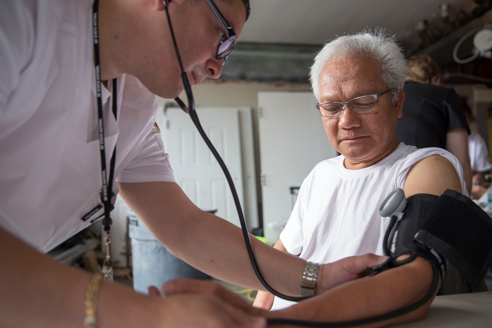 A student checking patient's blood pressure 