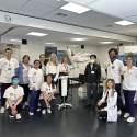 A group of smiling nursing students at a health care facility.