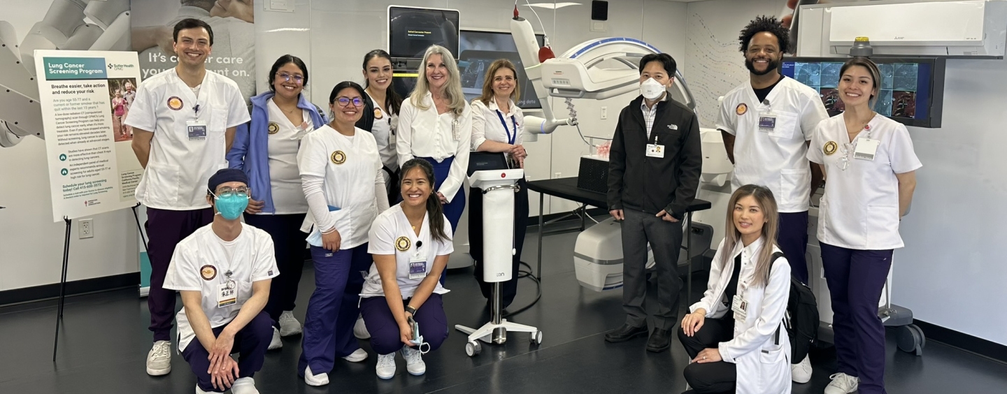 A group of smiling nursing students at a health care facility.